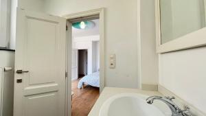 a white bathroom with a sink and a mirror at 201 Loft Lumineux en Hyper-Centre in Liège +23 photos