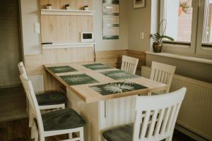 a table and chairs in a kitchen with a table and a table and chairsktop at Willa Murena in Mielno