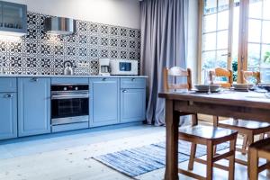 a kitchen with blue cabinets and a wooden table at Willa Leluja in Zakopane