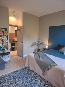 a bedroom with a large bed with a blue headboard at Inn the Green in Zeist