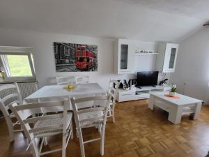 a dining room with a table and a red bus on the wall at Apartma Peric in Ljubljana +8 photos