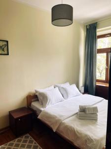 a bedroom with a bed with white sheets and a window at Bokeska apartment in Podgorica