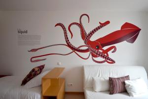 a wall with an octopus on it next to a couch at Casa da Baía - Guest House in Horta