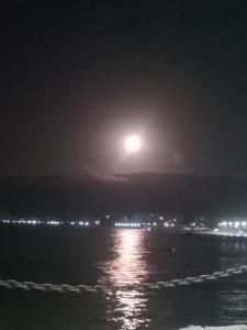 a full moon rising over the ocean at night at CasaRiquelme878 in Papudo