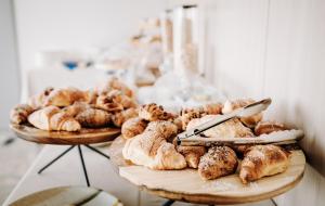 two plates of pastries and croissants on a table at Hotel Eldorado in Apiro