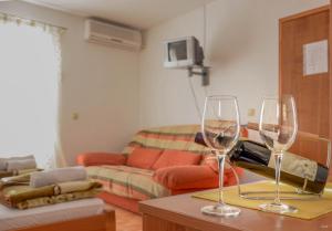 dos copas de vino sentadas en una mesa en una sala de estar en Apartments Drobni Pijesak, en Petrovac na Moru