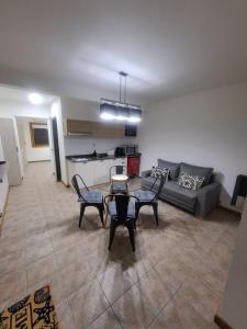 a living room with a couch and a table and chairs at departamento 2 amb en Av San Martin in San Martín de los Andes
