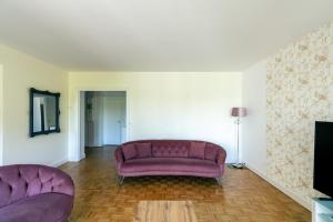 Una sala de estar con un sofá morado y un televisor. en Modern Apartment - Pont Mirabeau, en París