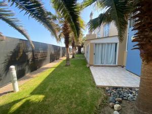 ein Haus mit Palmen davor in der Unterkunft Waterfront Cottage B3 in Swakopmund