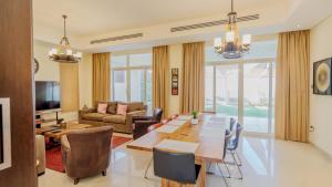 ein Wohnzimmer mit Tisch und Stühlen und einer Couch in der Unterkunft Beach Front Bermuda Villa Mina AlArab Ras Al Khaimah in Ras al Khaimah