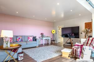Una sala de estar con un sofá azul y una mesa. en 1 Bed in Braunton oc-g32527, en Braunton