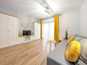 a living room with a couch and a television at Traugutta Angelcity GYM & SPA by BookingHost in Wrocław
