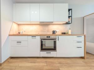 a kitchen with white cabinets and a sink at Traugutta Angelcity GYM & SPA by BookingHost in Wrocław