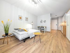 a white bedroom with a bed and a table at Traugutta Angelcity GYM & SPA by BookingHost in Wrocław