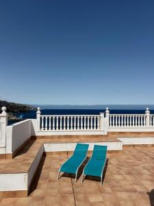 two blue chairs on a balcony with the ocean at LĀ KAI - Piso Carabelas in Candelaria