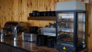 a kitchen with a counter with a display case with pizza at KarlovyVary Hotel Ankawa in Erbil