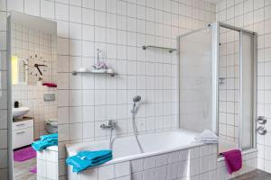 a bathroom with a bath tub with a shower at Ferienwohnung Burgblick in Plaue +22 photos