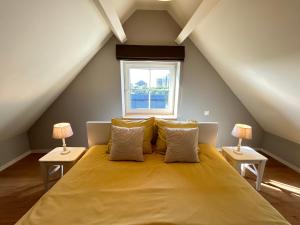 a bedroom with a large yellow bed with two lamps at Z' Evita in Nieuwpoort