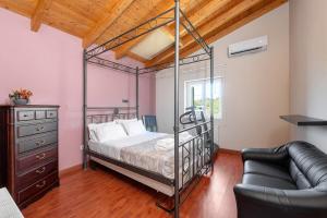 a bedroom with a metal bed and a couch at Paula Cozy Villa in Corfu in Áfra