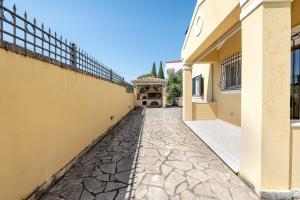 an empty alley between two buildings with a fence at Paula Cozy Villa in Corfu in Áfra