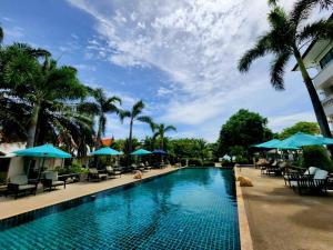 a pool at a resort with chairs and umbrellas at Bay Beach Resort in Choeng Mon Beach