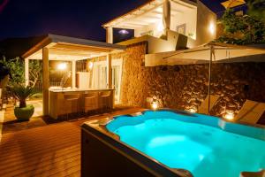 a hot tub in the backyard of a house at night at Dolceterra Eolian Villas in Lipari
