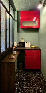 - une cuisine avec une armoire rouge et un four micro-ondes dans l'établissement Guest house Ema, à Sarajevo
