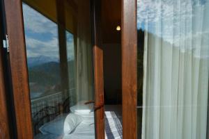 una porta a vetri aperta con vista su un balcone di Lam Lha a Mestia