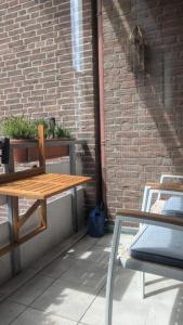 a wooden table and chairs next to a brick wall at Travemünde Kleine Perle in Lübeck