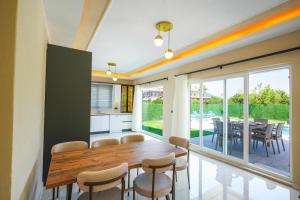 a dining room with a wooden table and chairs at Villa Albatross in Ortaca