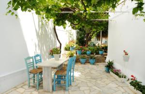 a table and chairs on a patio with potted plants at Nikoleta Rooms in Tinos +23 photos