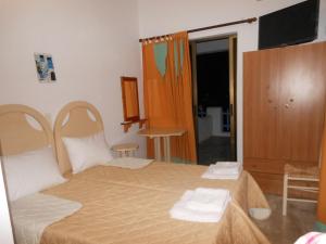 a bedroom with a bed with two towels on it at Gyrouli Studios in Astypalaia