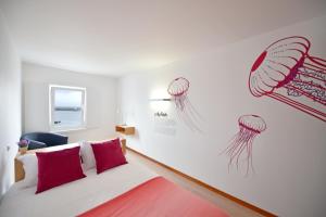 a bedroom with a bed with red pillows at Casa da Baía - Guest House in Horta