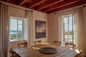 a dining room with a wooden table and two windows at Son Granot Hotel Rural in Es Castell