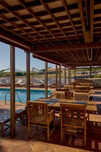 a restaurant with wooden tables and chairs and a pool at Son Granot Hotel Rural in Es Castell