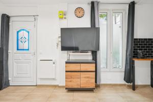 een woonkamer met een flatscreen-tv op een houten dressoir bij Beautiful renovated studio metro in Levallois-Perret