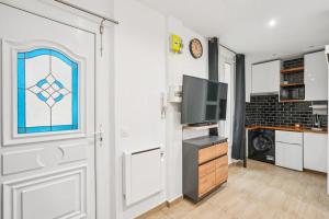 een kamer met een deur, een tv en een raam bij Beautiful renovated studio metro in Levallois-Perret