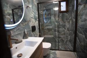 a bathroom with a sink and a shower at Kastrino Luxury Apartment in Ioannina