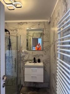 a bathroom with a sink and a mirror and a shower at Frăția Corsarilor in Sulina +15 photos