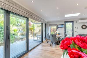 una sala da pranzo con porte scorrevoli in vetro e fiori rossi di 2 Bed in Heighington oc-c32585 a Heighington