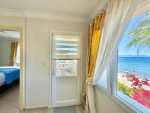 a bedroom with a window with a view of the beach at VITAMIN SEA Apartment in Ozdere