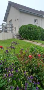 a house with a bunch of flowers in the yard at Chez Sylvia et Patrice in Saint-Léonard +2 photos