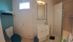 a bathroom with a white toilet and a sink at Chez Sylvia et Patrice in Saint-Léonard