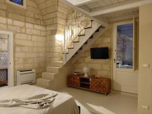 a bedroom with a staircase and a bed and a television at La Dimora dei Sapienti Luxury House in Melendugno