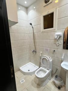 a bathroom with a toilet and a sink at الأجنحة المثالية للشقق المخدومة in Taif