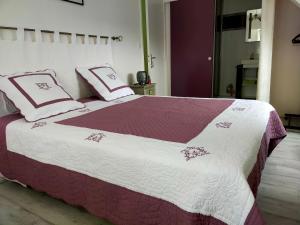 a bedroom with a bed with red and white sheets and pillows at Chez Coco in Trégunc