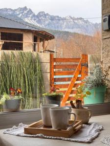 a table with two coffee cups on a window sill at Encanto Patagónico in El Bolsón +54 photos