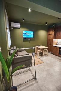 a room with a table and a tv on a wall at Bari in Acropolis in Athens