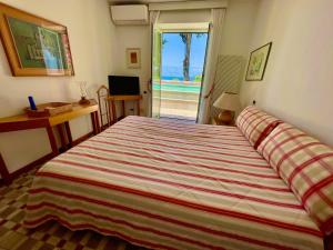 a bedroom with a bed with a view of the beach at Villa dei Galli - via Tragara in Capri +37 photos