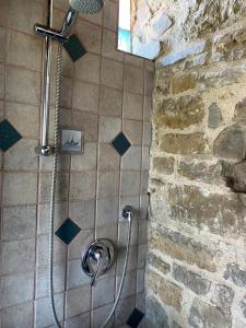 a shower in a bathroom with a stone wall at Ca Nova 1590 in Polinago +25 photos